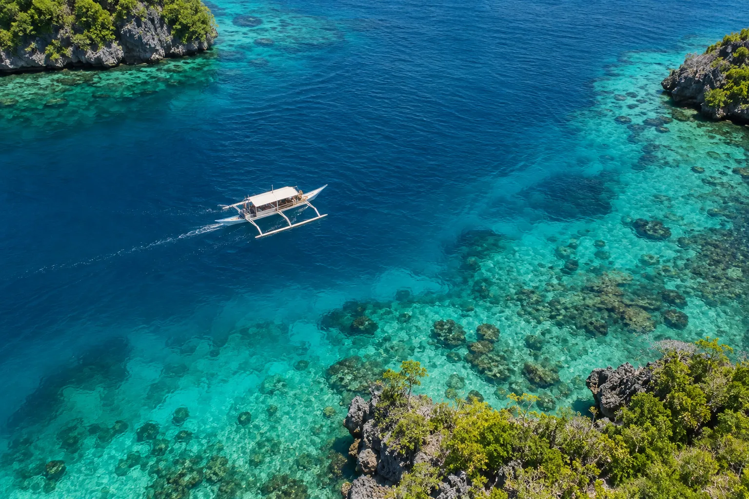 Illustrative aerial view of an outrigger boat near a tropical island, not a specific Mactan location